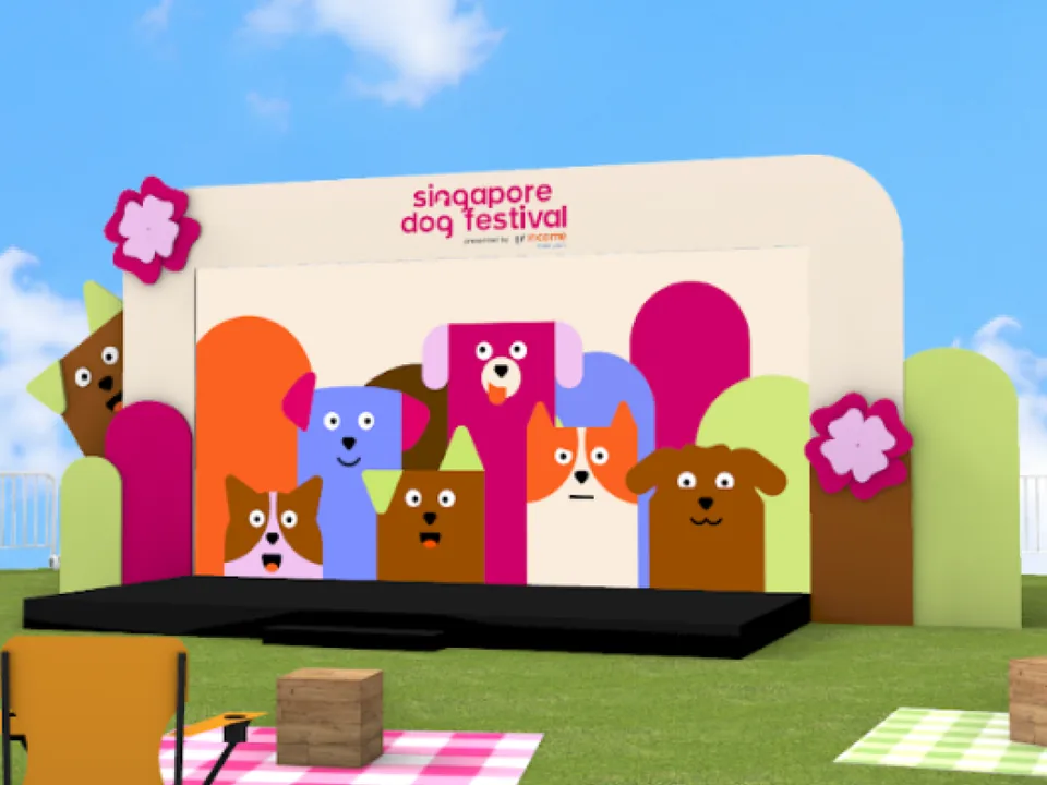 Render of the festival stage on grass, its backdrop painted with cartoon dogs